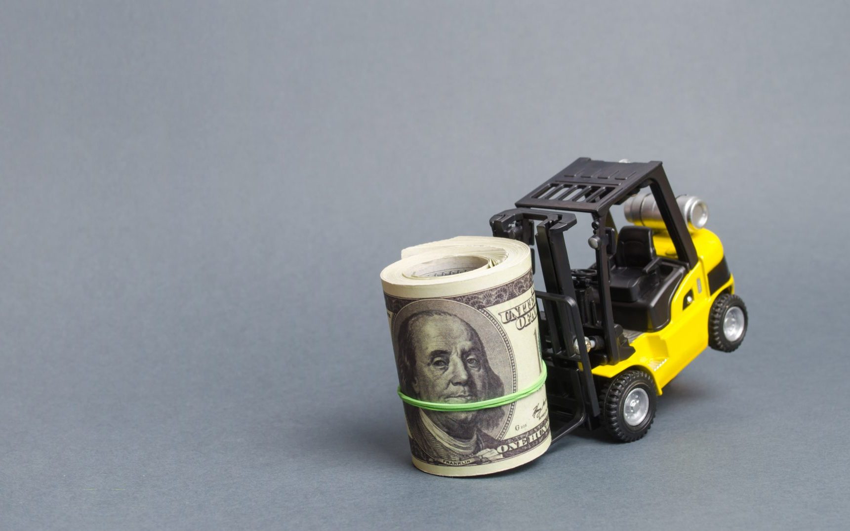 Yellow forklift truck can't lift a huge bundle of dollars. Expensive loans tax burden. attracting investment. High costs and barriers to business. Improving processes and logistics. Banner, copy space