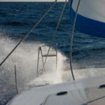 Sailing in strong wind with crashing waves on deck