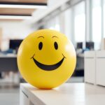 Positivity in the workplace demonstrated by a yellow smiling bal