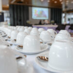 Group of many empty cups with spoons for service coffee or tea in seminar event or meeting room