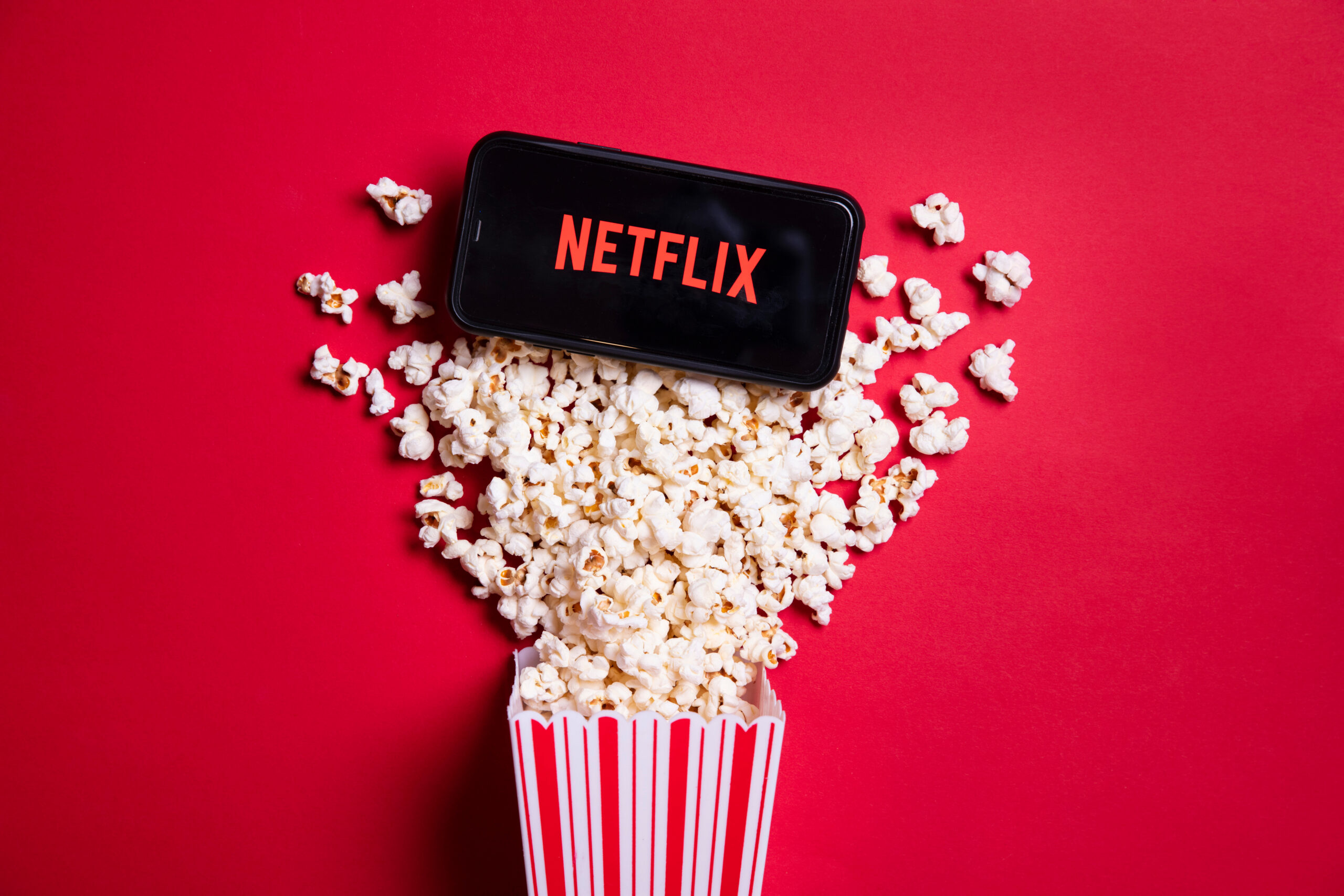 LONDON, UK - MAY 14 2020: Netflix logo on a smartphone with popc