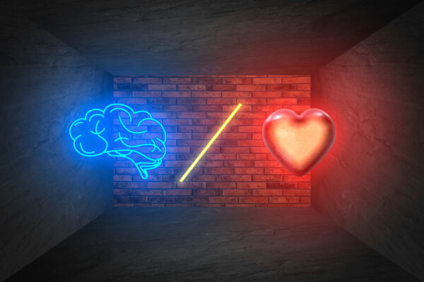 Choosing between logic and emotions. Illustrations of glowing heart, brain and slash symbol between them against brick wall in room with grey stone surfaces