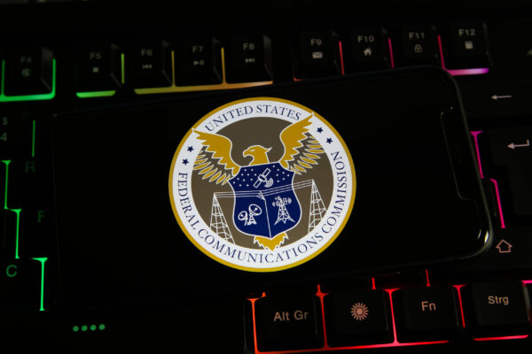 Viersen, Germany - March 9. 2022: Closeup of mobile phone screen with logo lettering of us federal communications commission on computer keyboard