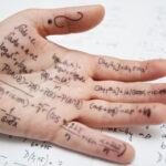 Hand of student with cheat sheet for math exam