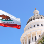 The image shows the California state flag. In the background, the domed white structure of the California State Capitol in Sacramento can be seen.