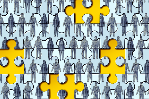 The image depicts a large jigsaw puzzle, with a majority of its pieces filled with illustrations of various business professionals in suits. he missing pieces seem to symbolize a gap or lack, possibly representing the concept of a missing workforce or skills gap, which could relate to industries such as cybersecurity.