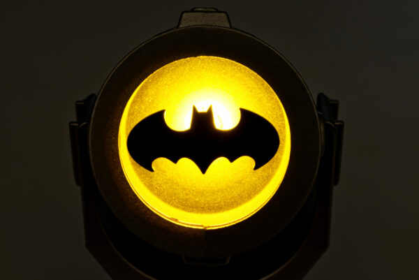 bologna - Italy - January 20, 2022: Illuminated Batsignal device isolated on dark background.