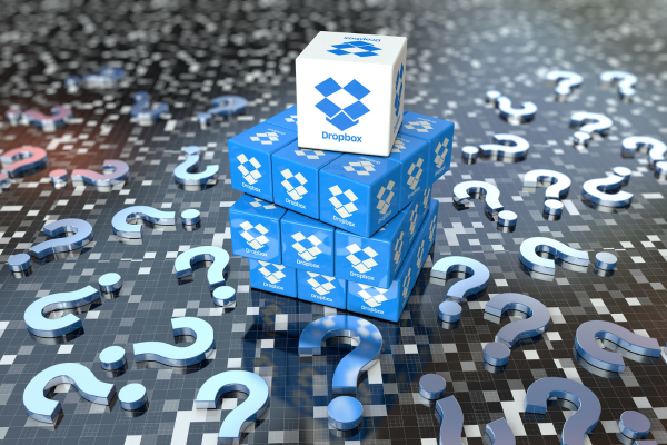 The image depicts a three-dimensional visualization of three stacked boxes branded with the Dropbox logo, situated on a reflective surface scattered with blue and silver question marks.
