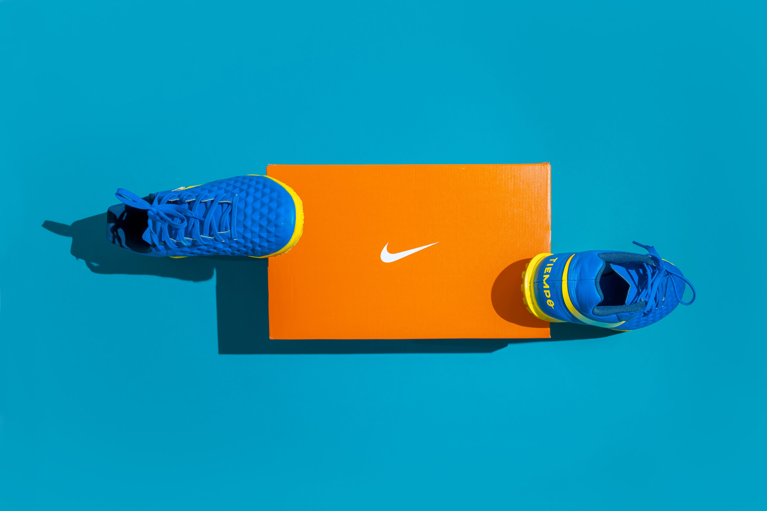 Nike sports shoes for men. Blue sneakers near the orange box.