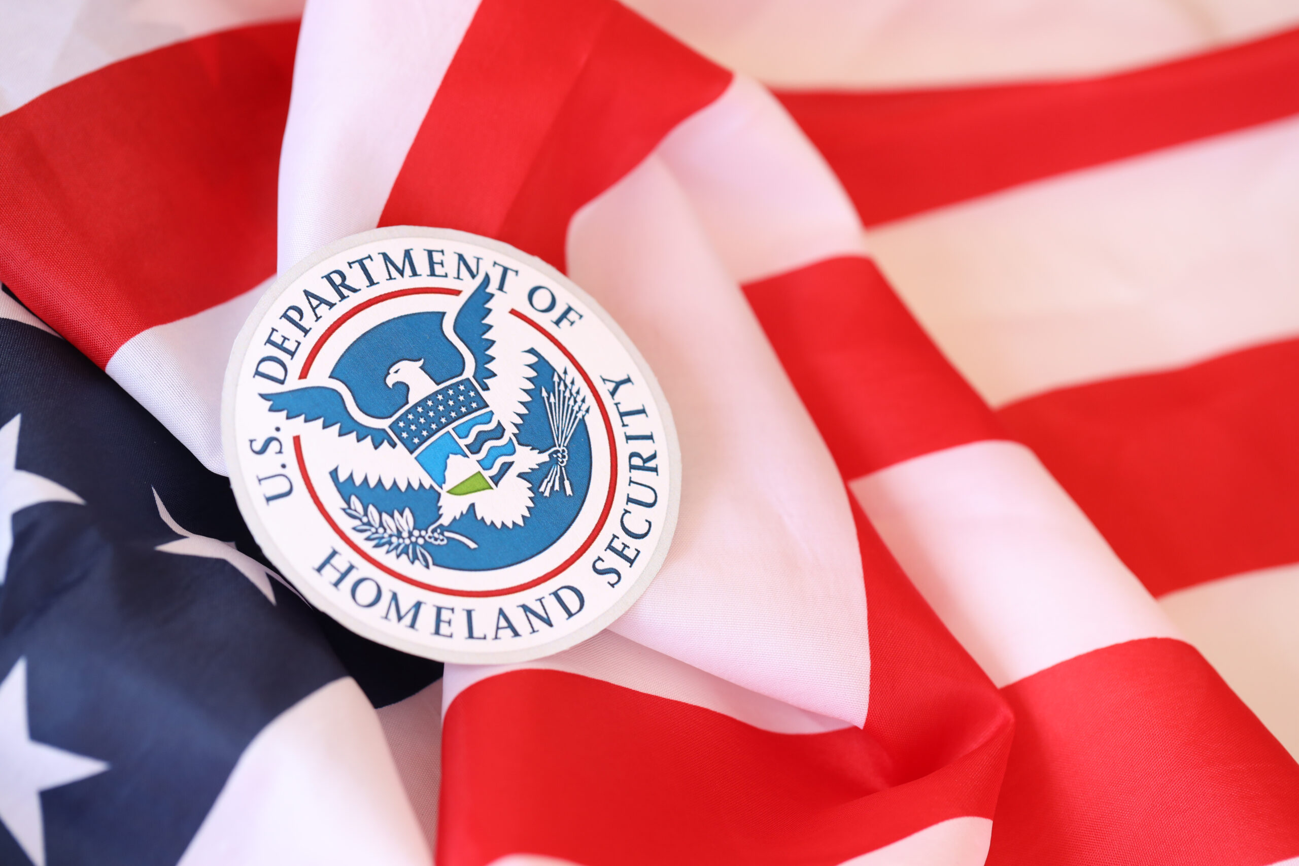 US Department of Homeland Security seal on United States of America flag close up.