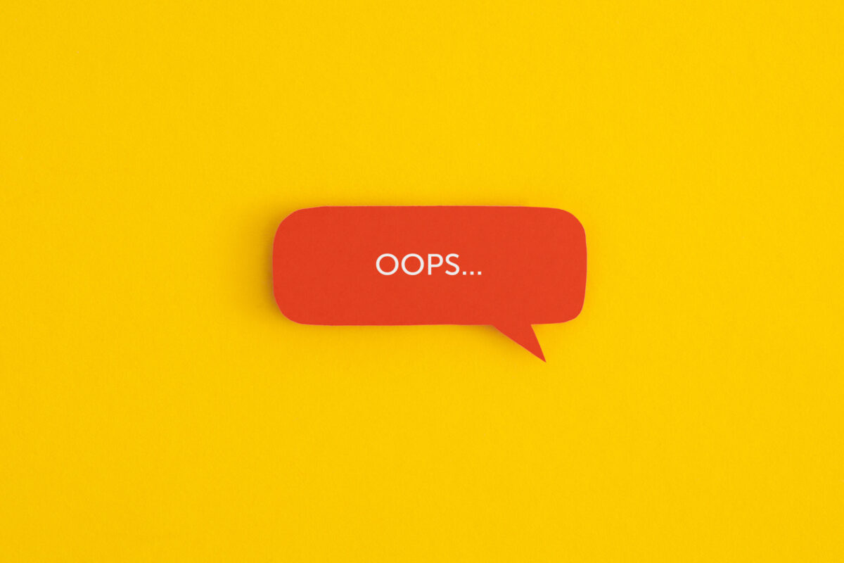 Paper speech bubble with the word "OOPS" on a yellow background. Top view with copy space. Flat lay.