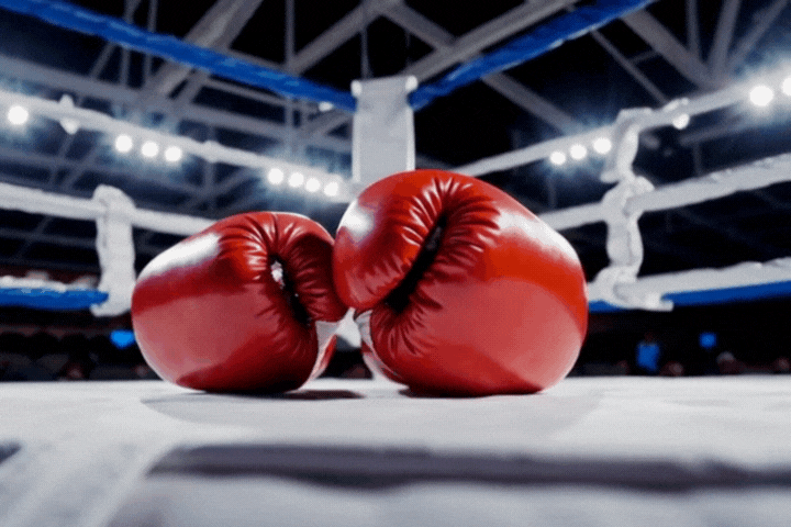 Boxing gloves laying in a vibrant and well lit boxing ring before a fight