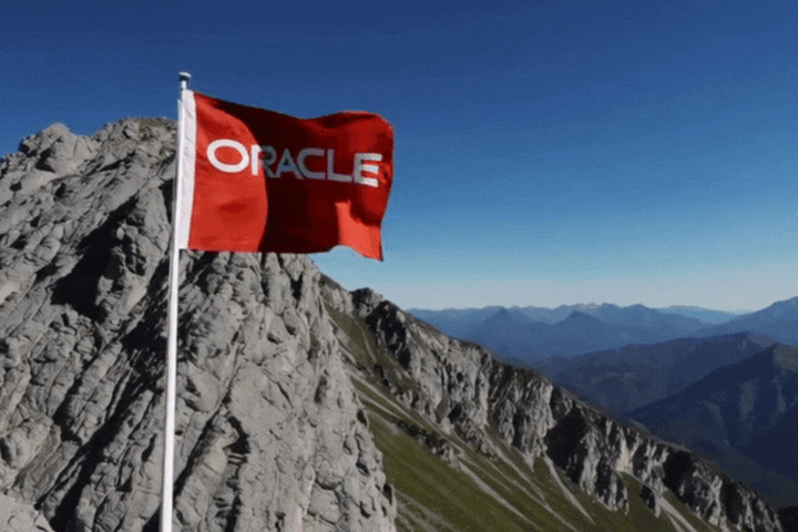 An "oracle" branded flag on top of a mountain
