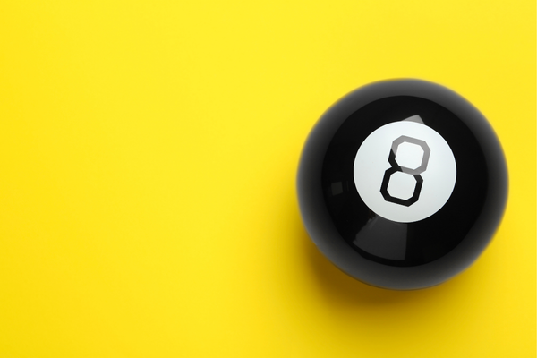 One magic eight ball on yellow background, top view. Space for text