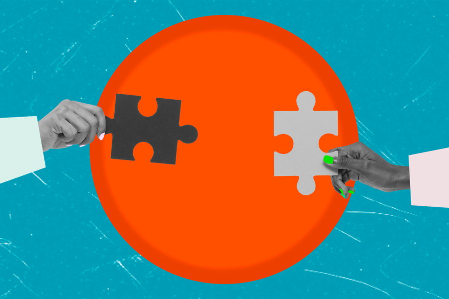 Hands connecting puzzle pieces on a blue background.