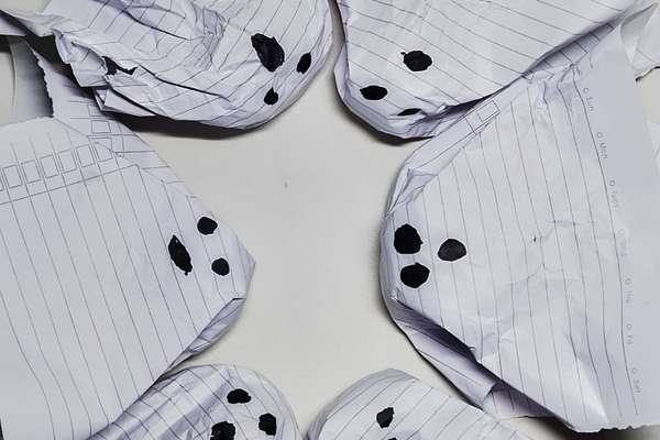 Creative concept of spooky Halloween ghosts made from crumpled lined paper, representing discarded ideas or mistakes arranged in a circle.