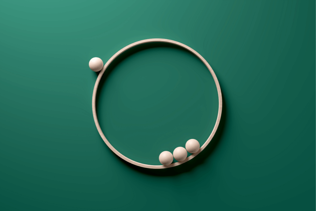 Exclusion, diversity and rejection concepts. Wooden spheres orbiting on a wooden circle ring on green background.