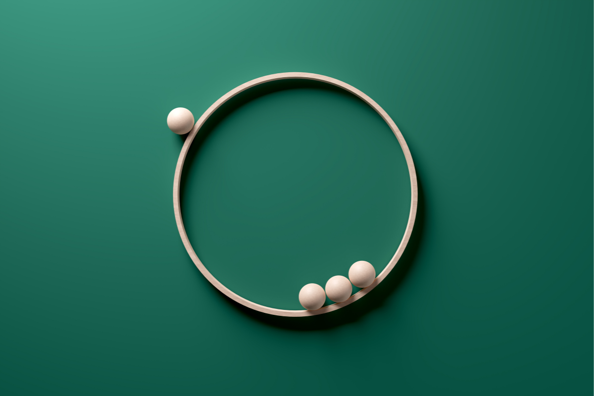 Exclusion, diversity and rejection concepts. Wooden spheres orbiting on a wooden circle ring on green background.