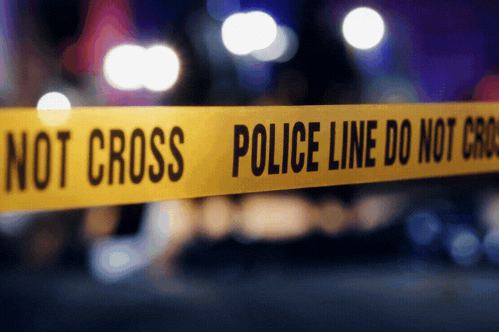 Close Up on Crime Scene Yellow Tape Showing Text "Police Line Do Not Cross"