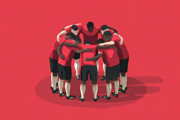 Soccer team in red uniforms huddling, a display of teamwork and unity