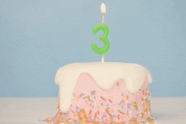 birthday cake with number three candle to celebrate 3rd birthday, seamless looping of cute cake with colorful candle number 3 for birthday annual celebrate party was lit, light blue background