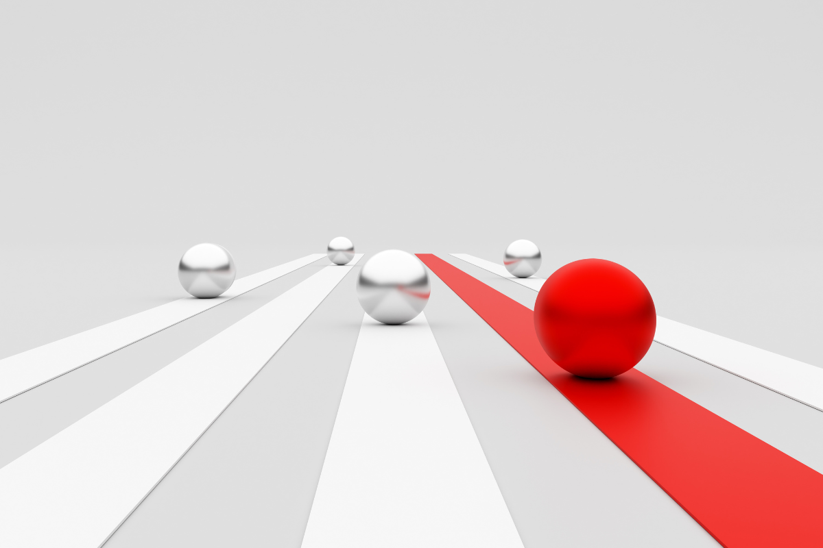 Red ball leading the race passing silver balls on white tracks