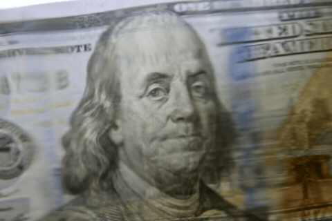 Animated image of Benjamin Franklin on a U.S. $100 bill, with financial imagery layered in the background.