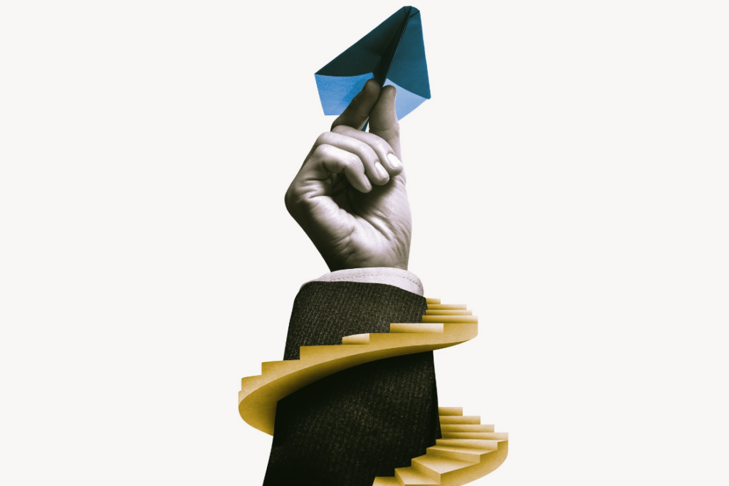 A spiral staircase next to a hand holding a paper airplane.