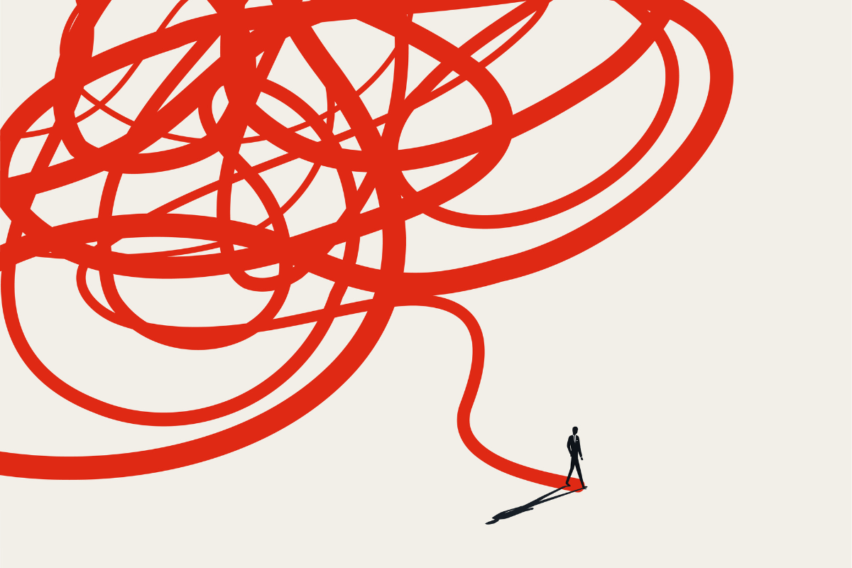 Silhouette of a businessman walking away from a giant tangled red knot onto a straight clear path.